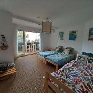 a bedroom with two beds and a balcony at Entre La Mer et Les Etoiles in Rayol-Canadel-sur-Mer