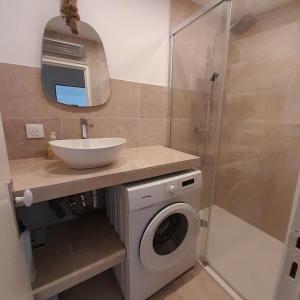 a bathroom with a washing machine and a sink at Entre La Mer et Les Etoiles in Rayol-Canadel-sur-Mer