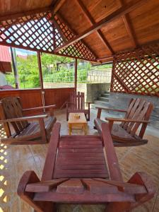 un portico con due sedie e un tavolo di Cervo Mountain House a Nehoiu