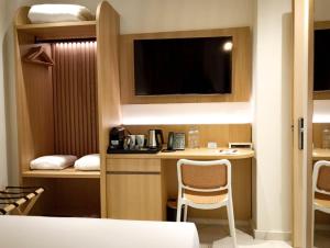 a room with a kitchen with a desk and a tv at Royal King David in Kardamaina