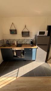 a kitchen with a sink and a refrigerator at Bel appartement cœur de village in Saint-André-de-Sangonis +3 photos