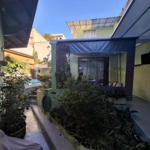 a house with a blue awning and a pool at Hostel Jardim da Saúde in Sao Paulo