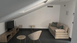 a living room with a couch and a tv at Hostal Dreamland in Gómezserracín