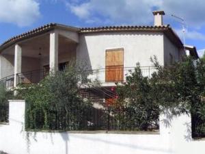 a white house with a fence in front of it at Sa domo manna in Porto Ottiolu