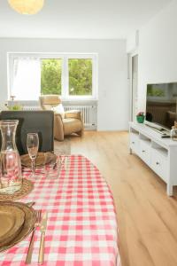 a living room with a table with a red and white checkered table cloth at Brody Apartments I Cozy Stay zwischen Friedberg und Bad Nauheim in Oberwöllstadt