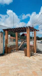a wooden pavilion with a table and a playground at APT Bela Cintra PRIME 3 km da praia do Aracagy in São Luís