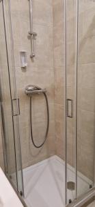 a shower stall with a glass shower door at Gare a pied Escale Authentique aux Portes de Paris in La Ferté-sous-Jouarre