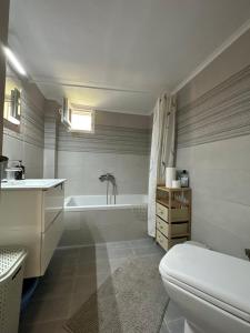 a bathroom with a tub and a toilet and a sink at Kiki's house Afytos in Afitos