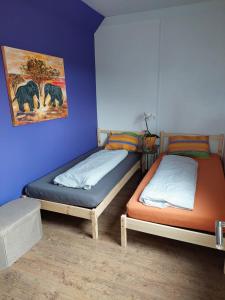 two twin beds in a room with blue walls at Weitblick Hof in Sankt Paul im Lavanttal
