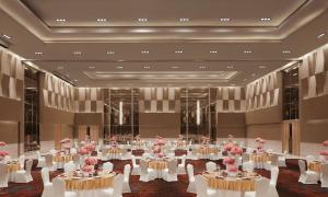 a large room with tables and chairs with pink flowers at Taj Bangalore in Devanahalli-Bangalore