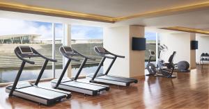 a gym with cardio equipment and a large window at Taj Bangalore in Devanahalli-Bangalore