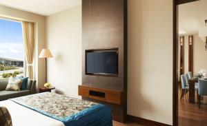 a hotel room with a bed and a flat screen tv at Taj Bangalore in Devanahalli-Bangalore