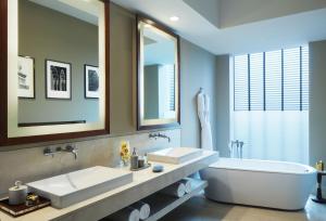 a bathroom with two sinks and a bath tub at Taj Bangalore in Devanahalli-Bangalore