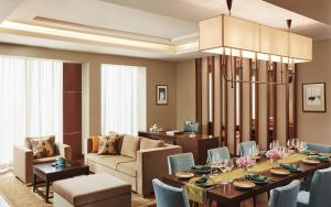 a dining room with a table and a living room at Taj Bangalore in Devanahalli-Bangalore