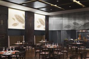 a dining room with tables and chairs and a stage at Taj Bangalore in Devanahalli-Bangalore