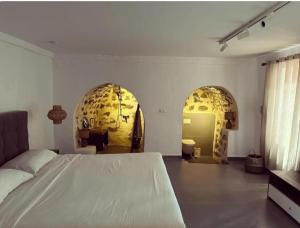 a bedroom with a white bed and two arches at Akil Villa in Dhërmi