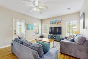 a living room with two couches and a flat screen tv at Down the Shore in Gulf Shores