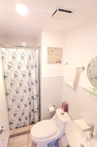 un bagno bianco con wc e doccia di F8 Deluxe Suite Ciudad de Guatemala, zona 10 a Guatemala Altre 34 foto