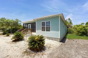 a blue house with a porch and some plants at Down the Shore in Gulf Shores