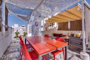 une table rouge et des chaises rouges sur un balcon dans l'établissement Casa Capitão by Enjoyyourstay, à Olhão