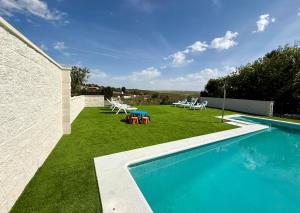 a backyard with a swimming pool and green grass at Ballestar Barajas de Melo 01 AMCH Hospedaje in Barajas de Melo