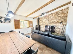 a dining room with a table and a brick wall at Ballestar Barajas de Melo 01 AMCH Hospedaje in Barajas de Melo