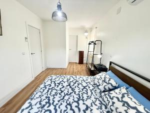 a bedroom with a bed with a blue and white comforter at Ballestar Barajas de Melo 01 AMCH Hospedaje in Barajas de Melo +52 photos