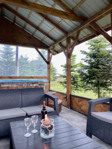 a table with a bottle of wine on a patio at Kwatera - Pod Wiatrakiem, JACUZZI ZEWNĘTRZNE in Czarna