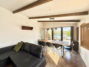 a living room with a black couch and a wooden table at Ballestar Barajas de Melo 01 AMCH Hospedaje in Barajas de Melo