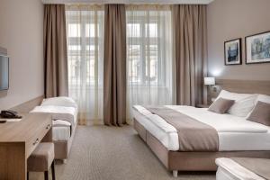 a hotel room with two beds and a desk at Hotel Florenc in Prague