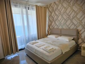a bedroom with a bed and a large window at Sunset Luxury Apartment in Vlorë +28 photos