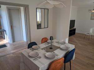 a dining room table with a white table cloth and chairs at maison cosy et tout équipé et fraiche- 5 min du zoo et proche des châteaux in Noyers-sur-Cher