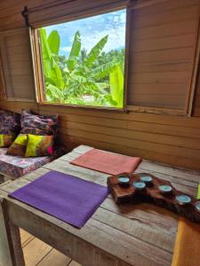 a room with a table with mats and a window at Jo's Nature Cabin in SantʼAna