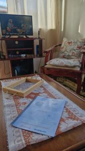 een woonkamer met een tafel met een toetsenbord en een bank bij Kitnet Praiano- Praia de Olaria in Majé