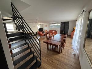 a living room with a staircase and a table and chairs at Les maisons Inael in Pénestin