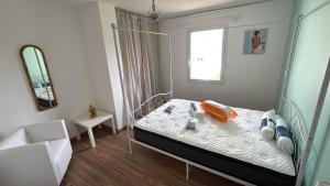 a bedroom with a canopy bed and a mirror at Les maisons Inael in Pénestin
