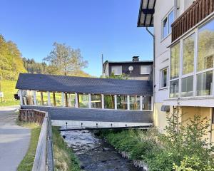 a building with a black roof next to a river at Smart Resorts B&B 1 BB1 201 in Winterberg
