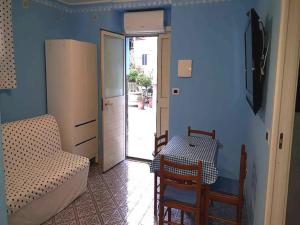 Habitación con mesa, sofá, mesa y silla. en Bilocale Nefele, en Giardini Naxos