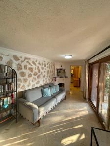 a couch in a room with a stone wall at Villa Olive Garden, Kalkan ClubPatara in Kalkan