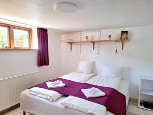 a bedroom with a white bed with towels on it at Cosy VOGI Flat in Ikast