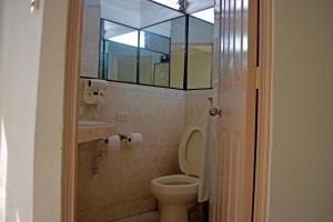 a bathroom with a toilet and a sink and a window at Hotel Bresciani in La Aurora +24 photos