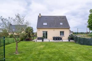ein Haus mit einem Rasen davor in der Unterkunft La Brocéliande enchantée in Iffendic