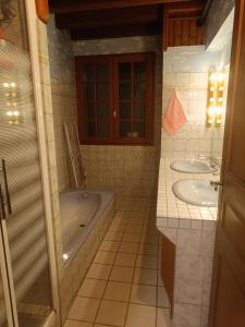 een badkamer met 2 wastafels en een bad bij Corneguerre Grand Brassac in La Peyzie