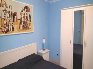 1 dormitorio con 1 cama y una pintura en la pared en Bilocale Nefele, en Giardini Naxos