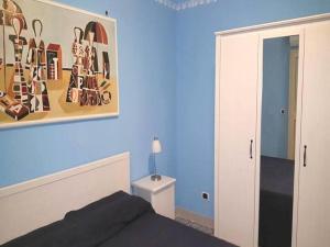 ジャルディーニ・ナクソスにあるBilocale Nefeleのベッドルーム1室(ベッド1台付)が備わります。壁には絵画が飾られています。