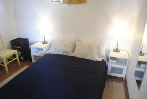 a bedroom with a large bed with two lamps at Casa da Baixa da Ribeirinha in Baixa