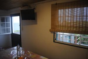 a kitchen with a table and a window with blinds at Casa da Baixa da Ribeirinha in Baixa
