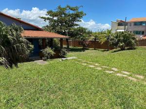 a yard with a house and a brick fence at SA · Beachfront Saquarema: Your beach house! in Saquarema