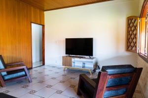 a living room with a flat screen tv on a wall at SA · Beachfront Saquarema: Your beach house! in Saquarema