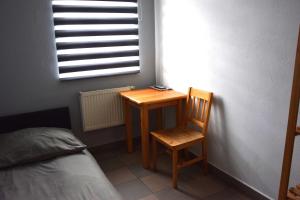 a bedroom with a desk and a chair next to a bed at Villa Basia in Rybnik